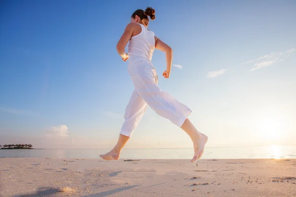 Kaukasisk kvinna jogging på havsstranden — Stockfoto