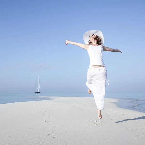 Щаслива молода жінка стрибає на пляжі — стокове фото