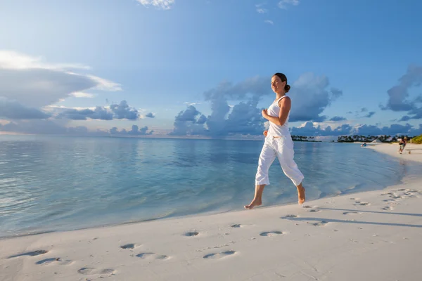 Mujer caucásica trotando en la orilla del mar — Foto de Stock