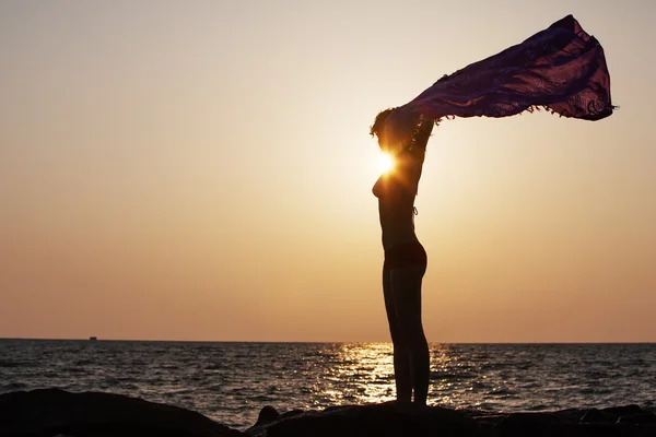 Silhouette of woman that stands against sunset sun at the seasho — Stock Photo, Image