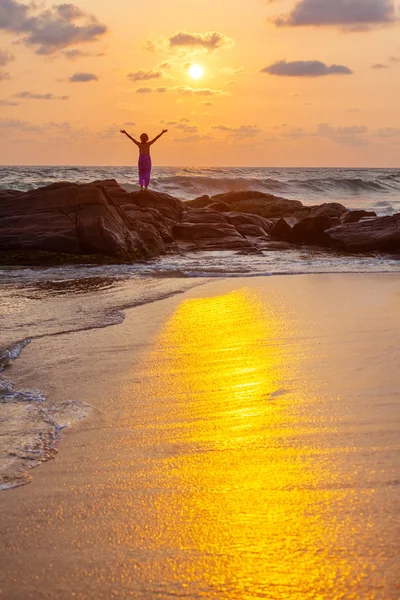 Donna saluta sole la riva del mare durante l'alba — Foto Stock