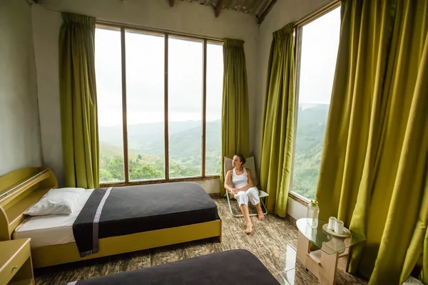 Wanita duduk di kursi berlengan nyaman di hotel tinggi di pegunungan — Stok Foto