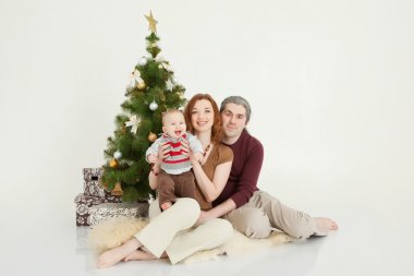 Mutlu aile yeni yıl ağacı üzerinde beyaz stüdyo oturma