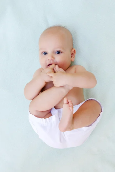 Babyjongen speelt alleen op witte handdoek — Stockfoto