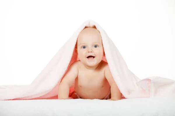 Caucasian baby boy covered with pink towel joyfully smiles at ca — Stock Photo, Image