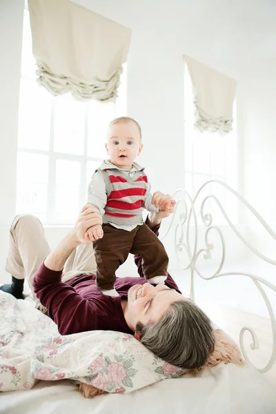 Padre e hijo relajándose juntos en la cama — Foto de Stock