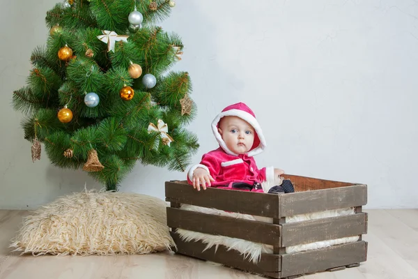 Malý chlapec v obleku Santa hraje v bílém studio — Stock fotografie