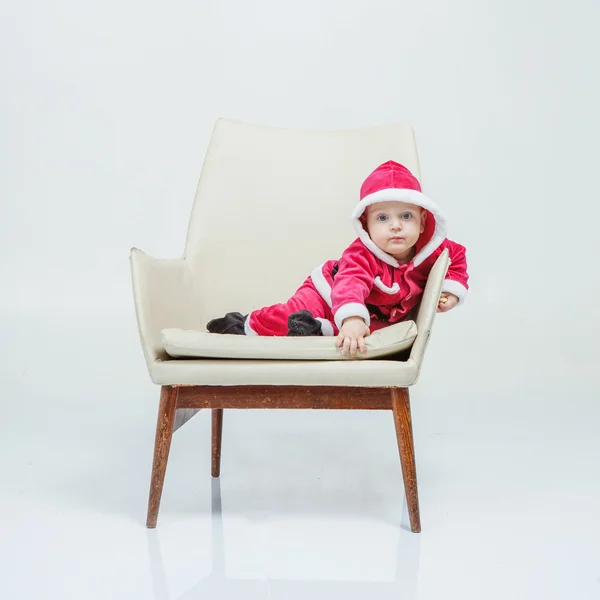 Niño en traje de Santa juega en estudio blanco — Foto de Stock