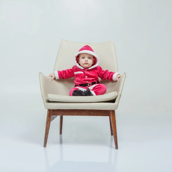 Small boy in Santa suit plays in white studio — Stock Photo, Image