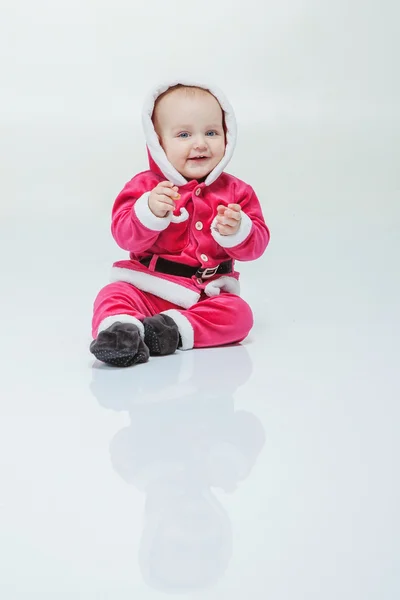 Menino pequeno em terno de Santa joga no estúdio branco — Fotografia de Stock