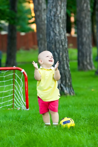 Lilla kaukasiska pojke spelar fotboll i parken — Stockfoto