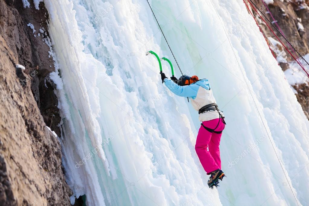 Woman climbing frozen waterfall