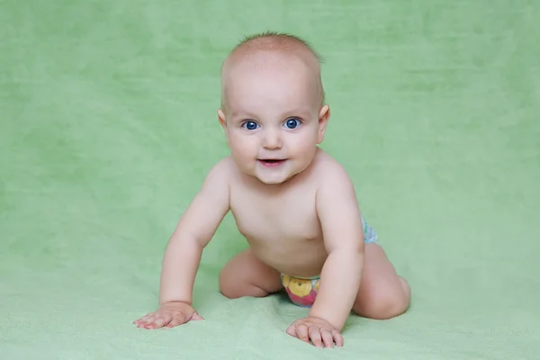 Schattige babyjongen tegen groene achtergrond — Stockfoto