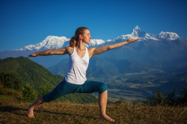Genç kadın pratik yoga karşı Himalaya Dağları