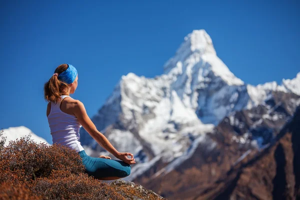 Junge Frau praktiziert Yoga gegen Himalaya-Berge — Stockfoto