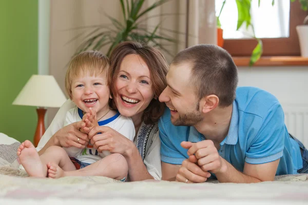 Jóvenes padres atractivos y retrato infantil en interiores — Foto de Stock