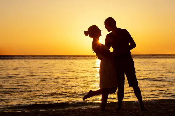 Romantikus pár a strandon a színes naplemente a háttérben — Stock Fotó
