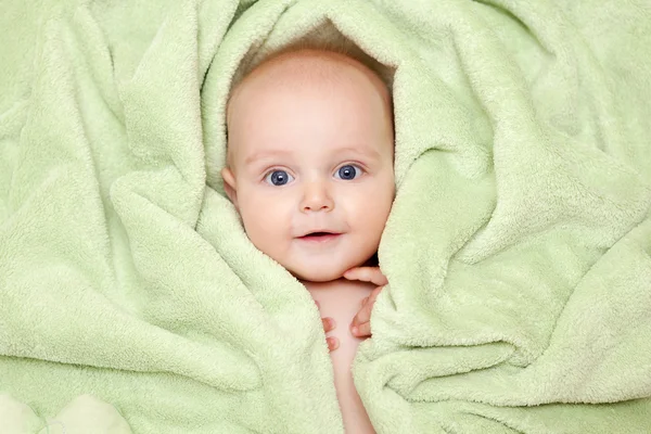 Caucasico bambino ragazzo coperto con verde asciugamano gioiosamente sorride a c — Foto Stock