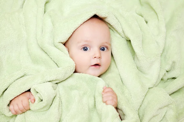 Kaukasische jongetje bedekt met groene handdoek vreugdevol glimlach bij c — Stockfoto