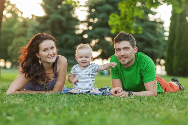 Jóvenes padres atractivos y retrato infantil al aire libre — Foto de Stock