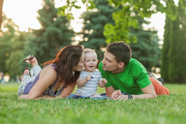 Jóvenes padres atractivos y retrato infantil al aire libre — Foto de Stock