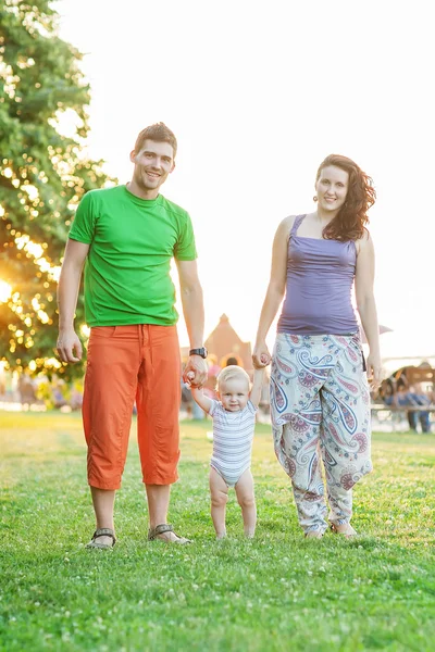 Jóvenes padres atractivos y retrato infantil al aire libre — Foto de Stock