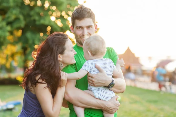 Jóvenes padres atractivos y retrato infantil al aire libre — Foto de Stock