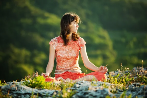 Ung kvinna utövar yoga i höga berg — Stockfoto