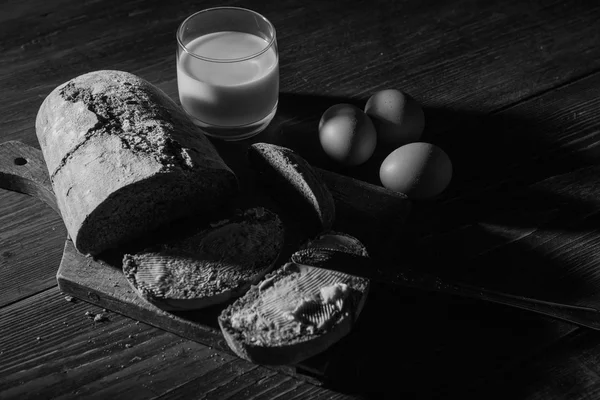 Kenyér, vaj és a tojás, a woodent asztal-ban alacsony-könnyű sty — Stock Fotó