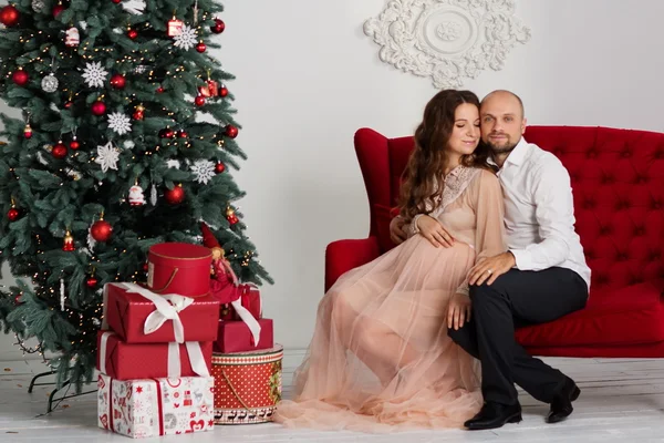 Feliz casal grávida perto da árvore de Natal — Fotografia de Stock