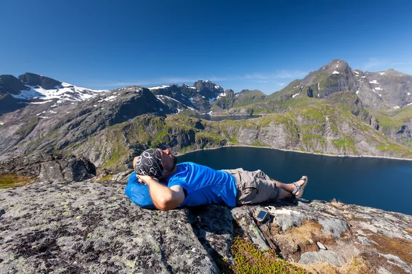El hombre descansa en la cima de la montaña en Noruega — Foto de Stock