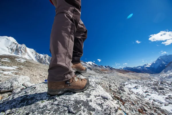Bota de senderismo primer plano en rocas de montaña — Foto de Stock