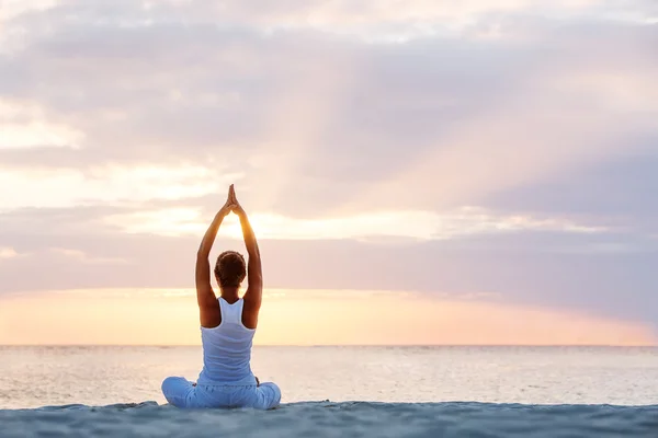 Kaukasische Frau praktiziert Yoga an der Küste — Stockfoto