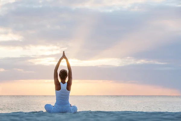 Mujer caucásica practicando yoga en la orilla del mar — Foto de Stock