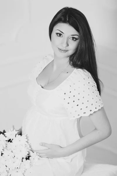 Красива вагітна жінка вдома дивиться на камеру — стокове фото