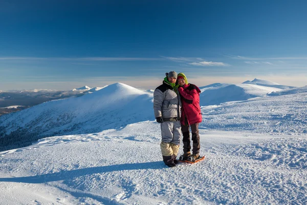 Dois caminhantes posando na câmera em montanhas de inverno — Fotografia de Stock