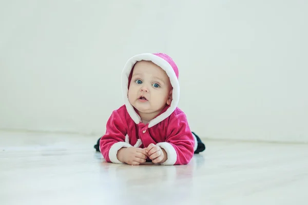 Small boy in Santa suit plays in white studio — Stock Photo, Image