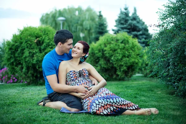 Casal grávida posando no parque — Fotografia de Stock