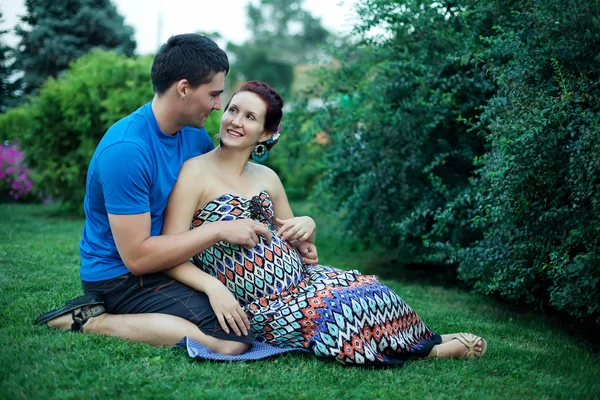 Casal grávida posando no parque — Fotografia de Stock