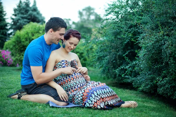Pareja embarazada posando en el parque — Foto de Stock