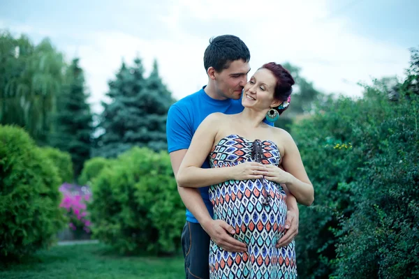 Pareja embarazada posando en el parque — Foto de Stock