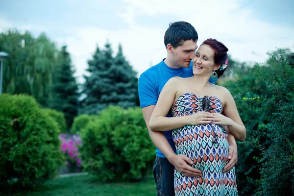 Casal grávida posando no parque — Fotografia de Stock