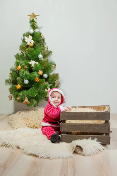 Malý chlapec v obleku Santa hraje v bílém studio — Stock fotografie