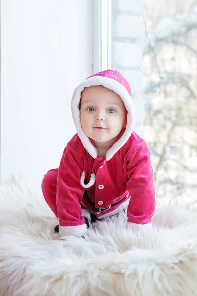 Small boy in Santa suit plays in white studio — Stock Photo, Image