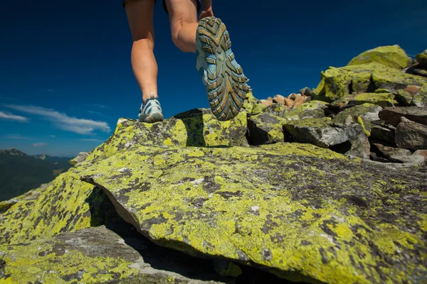 Vrouw atleet is springen over stenen in Bergen — Stockfoto