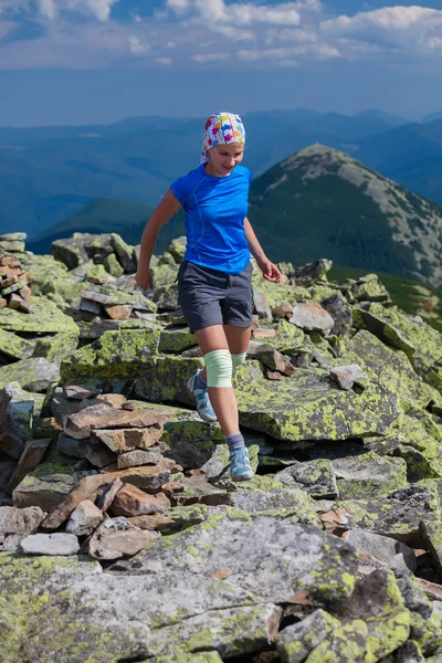 Mujer atleta está saltando sobre piedras en las montañas —  Fotos de Stock