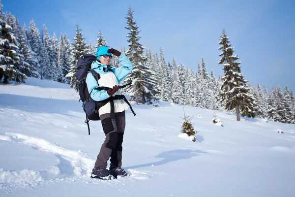 Wanderer sucht den Weg auf der Karte im Schneewald — Stockfoto