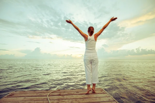 Mujer caucásica practicando yoga en la orilla del mar — Foto de Stock