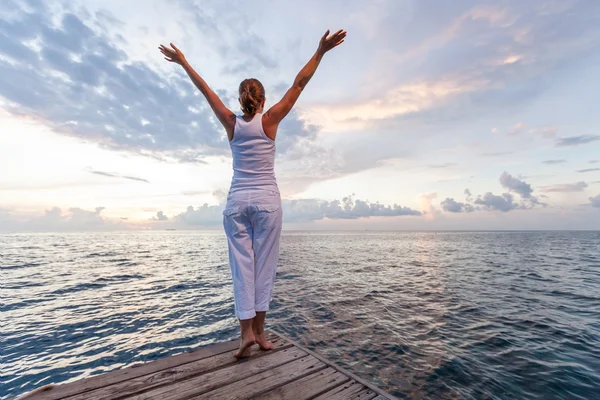 Kaukasische vrouw beoefenen van yoga in kust — Stockfoto