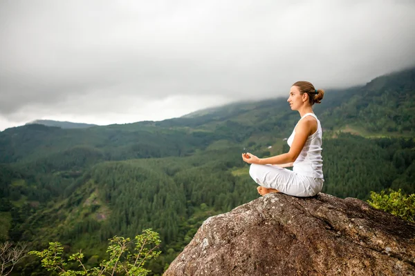 Kvinnan gör yogaövningar i bergen — Stockfoto